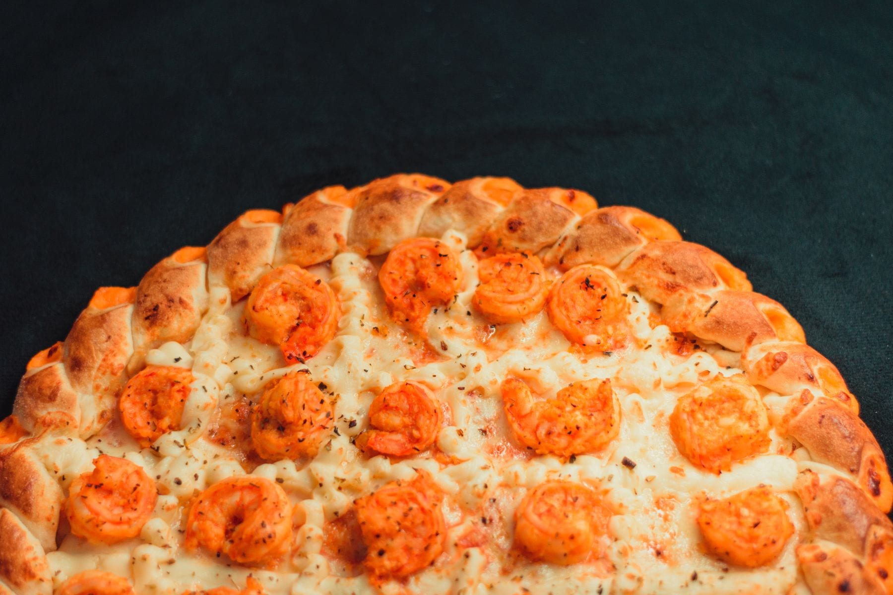 Pizza com borda recheada em fundo escuro