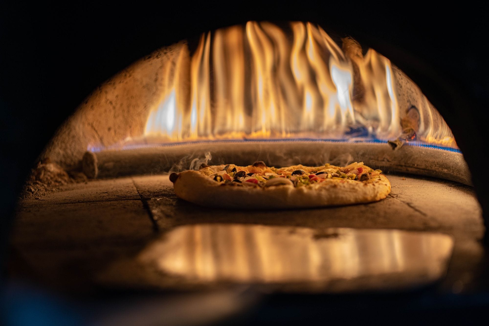 Chamas do forno a lenha aquecendo a pizza