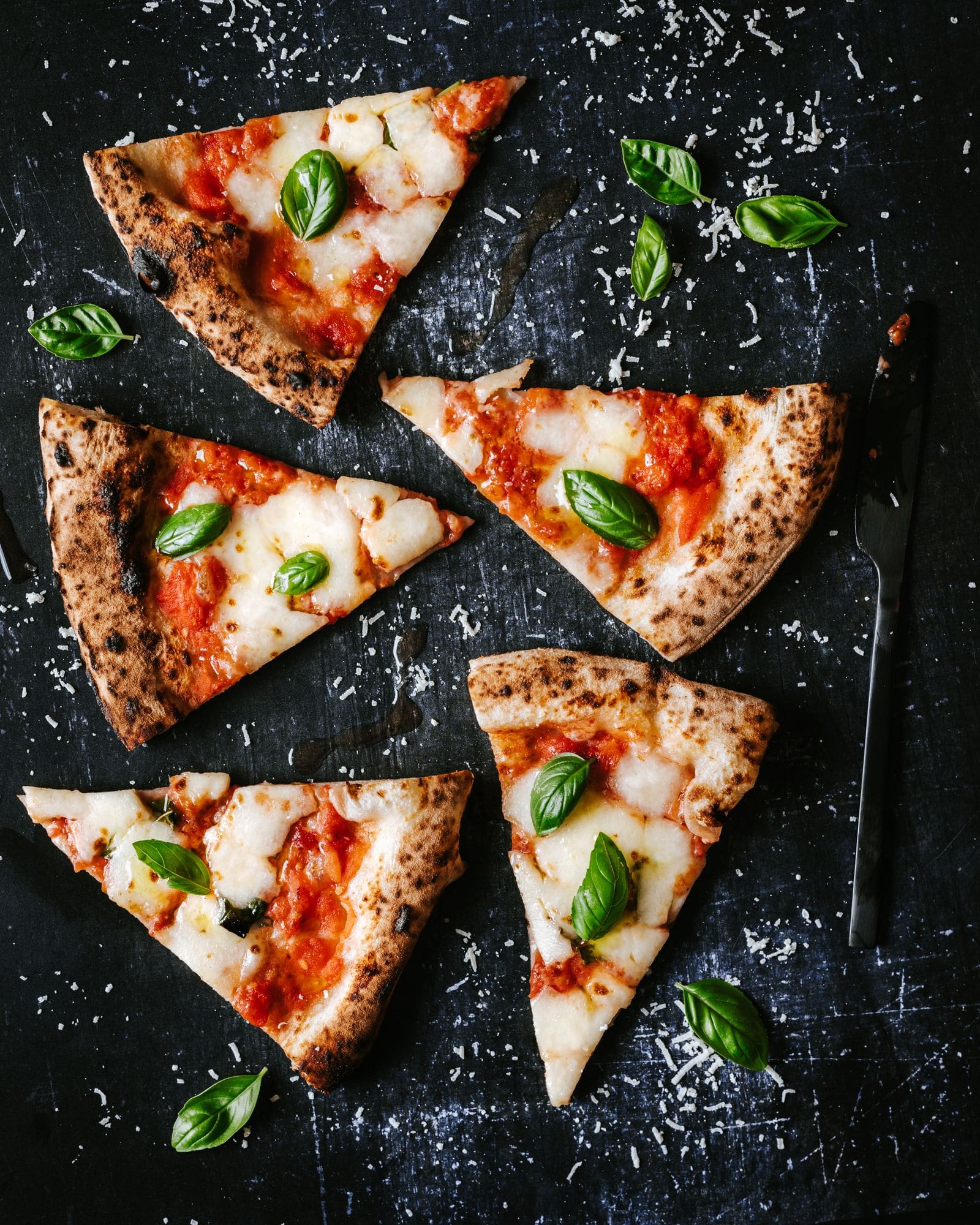 Fatias de pizza margherita sobre ardósia escura
